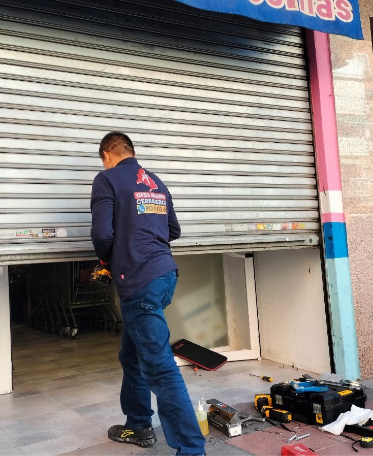 cerrajero profesional instalando una persiana metálica en un local comercial en Fuenlabrada
